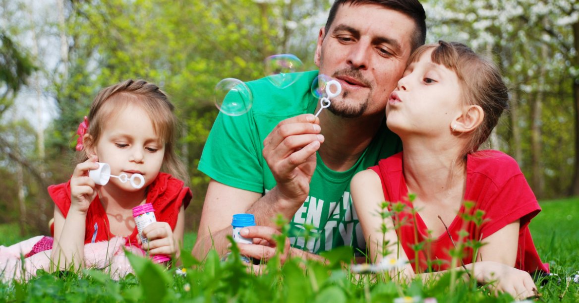 single dad blowing bubbles with daughters in the summertime wonders if he can suspend child support while they're with him